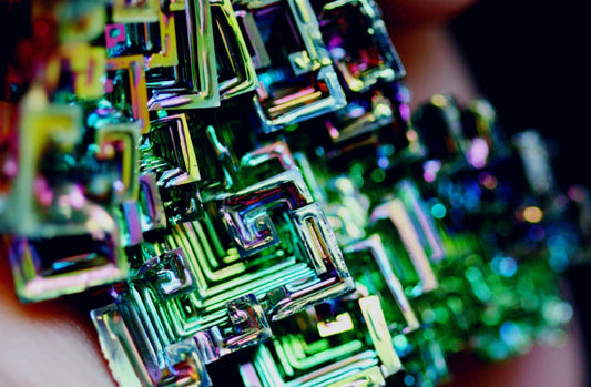 鉍的階梯晶（Hopper Crystal）呈現層層退縮的幾何階梯與虹彩干涉色。